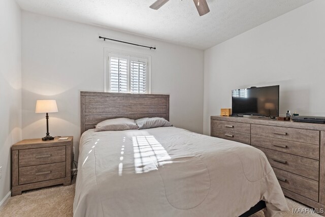 bedroom with light carpet, a textured ceiling, and ceiling fan