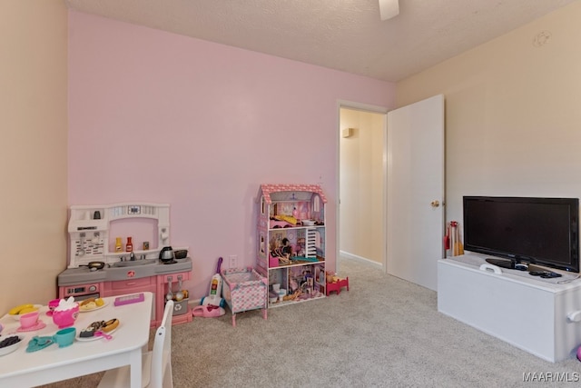 playroom with a textured ceiling and light carpet