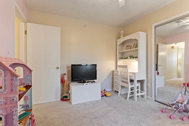 game room with light colored carpet and a textured ceiling