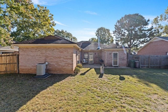 rear view of property featuring a yard and central AC unit