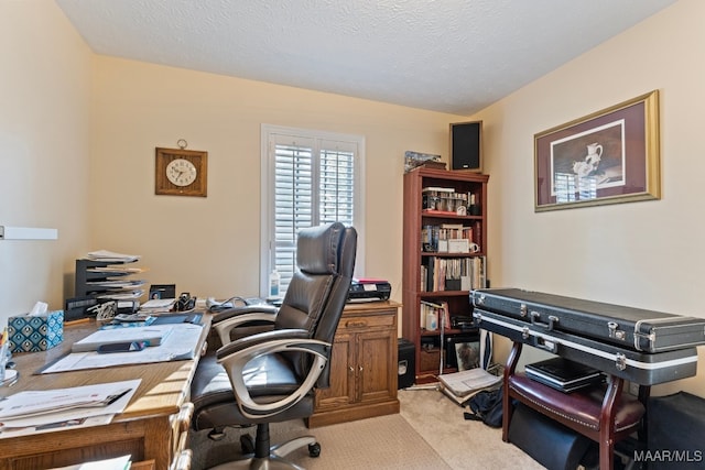 carpeted home office featuring a textured ceiling