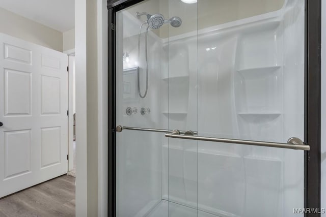 bathroom featuring a shower with door and wood-type flooring