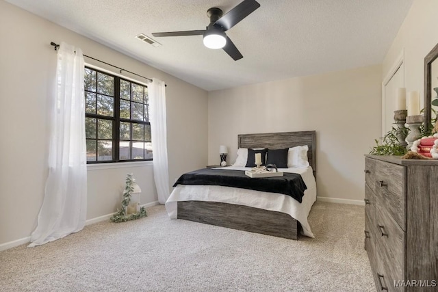 bedroom featuring carpet flooring, a textured ceiling, and ceiling fan