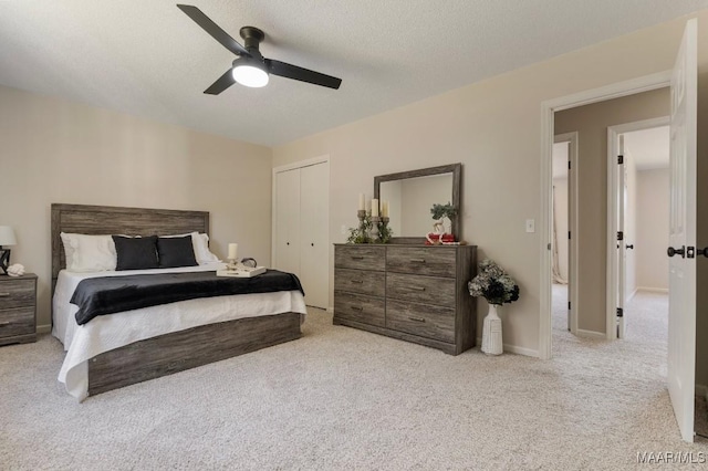 carpeted bedroom with ceiling fan, a textured ceiling, and a closet