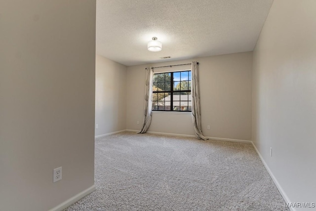 unfurnished room featuring light colored carpet and a textured ceiling