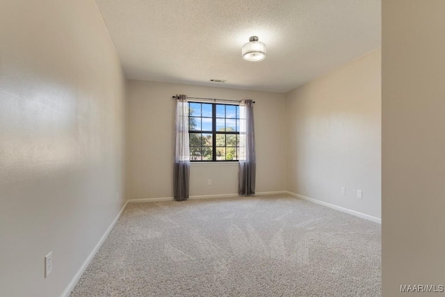 unfurnished room with carpet and a textured ceiling