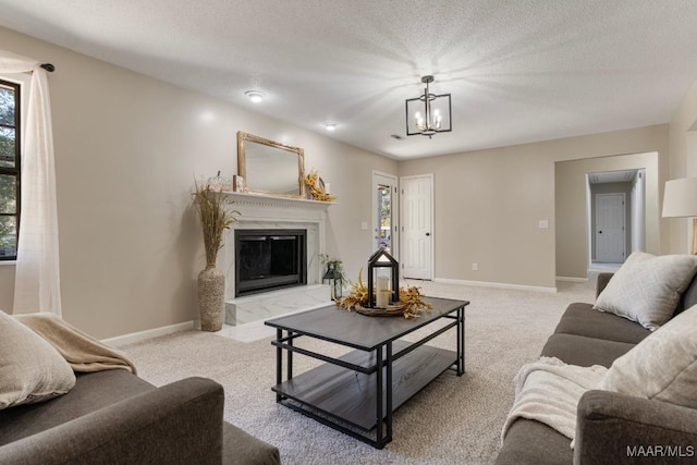 living room with a chandelier, a fireplace, light colored carpet, and a textured ceiling