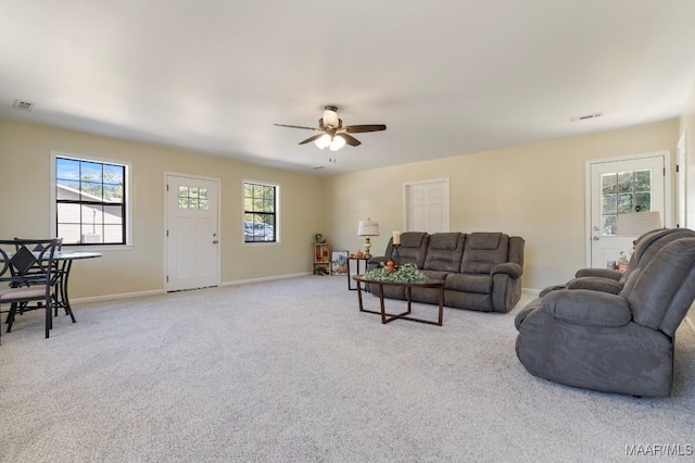 carpeted living room with ceiling fan