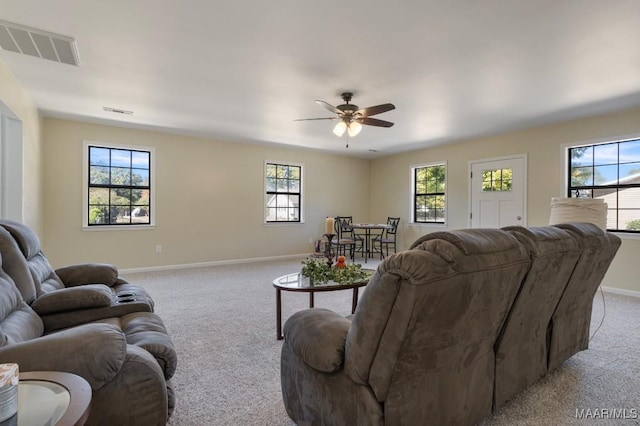 living room with light colored carpet, a wealth of natural light, and ceiling fan