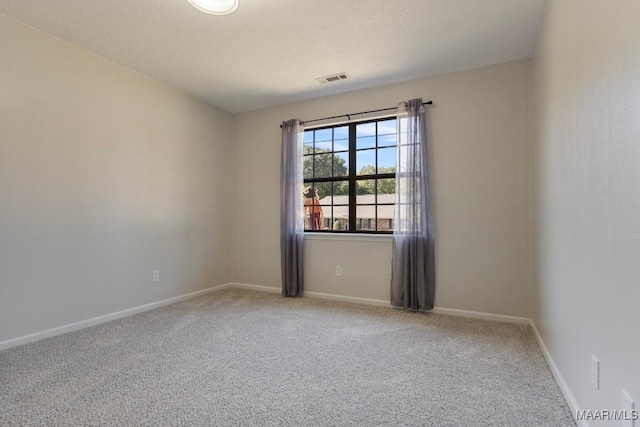 spare room featuring carpet and a textured ceiling