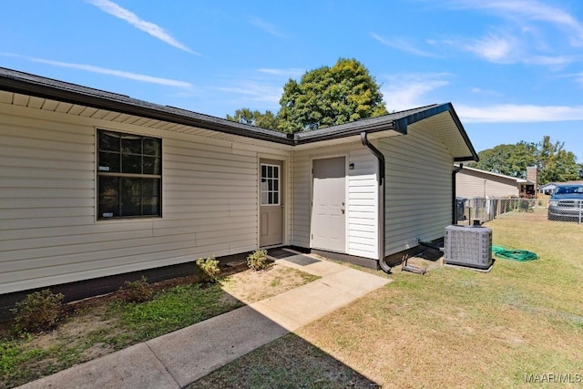 property entrance with a lawn and central air condition unit