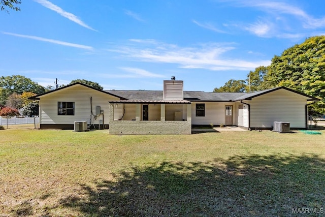 rear view of house featuring a lawn and central AC