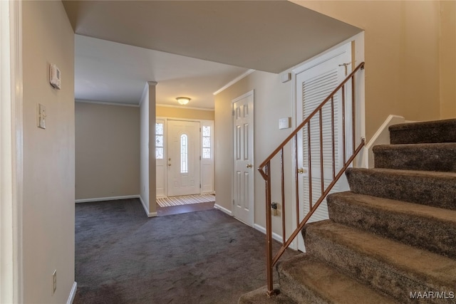 foyer featuring crown molding and dark colored carpet