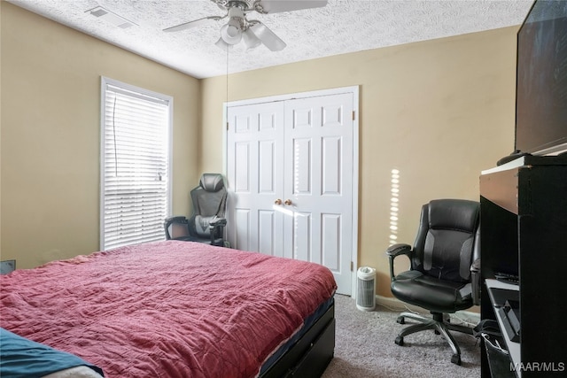 bedroom featuring a closet, ceiling fan, carpet flooring, and a textured ceiling