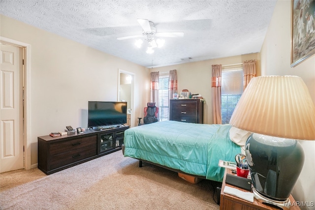 carpeted bedroom featuring a textured ceiling and ceiling fan