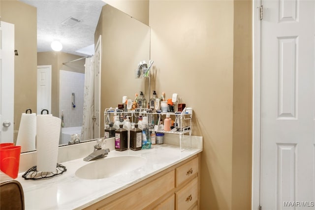 bathroom featuring vanity, shower / bath combo with shower curtain, and a textured ceiling