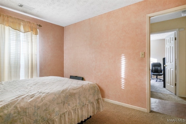 carpeted bedroom featuring a textured ceiling