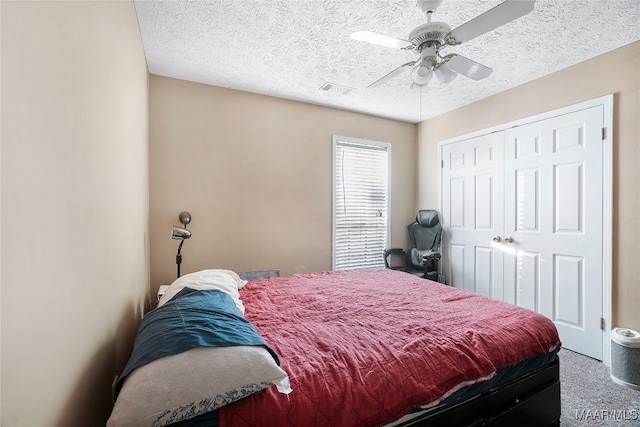 carpeted bedroom with a textured ceiling, a closet, and ceiling fan