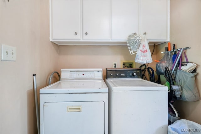 washroom featuring cabinets and washer and clothes dryer