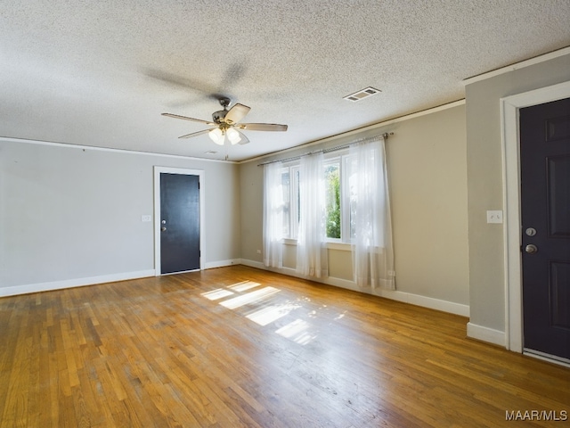 unfurnished room with ceiling fan, a textured ceiling, ornamental molding, and hardwood / wood-style floors