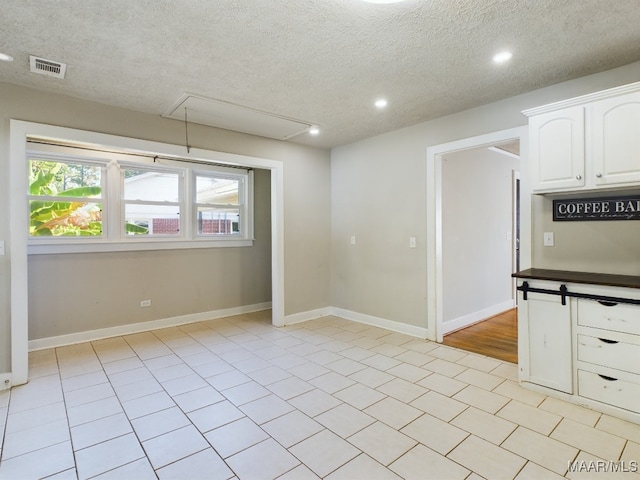 tiled empty room with a textured ceiling