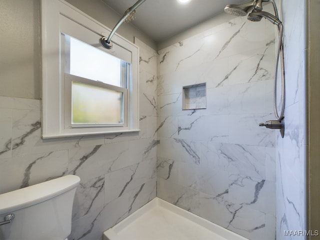 bathroom with a tile shower, toilet, tile walls, and ceiling fan