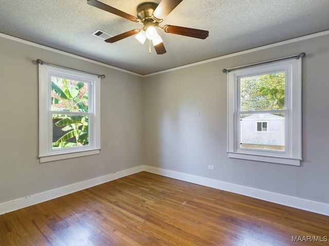 unfurnished room featuring a textured ceiling, ceiling fan, a wealth of natural light, and dark hardwood / wood-style flooring