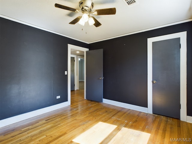 empty room featuring light hardwood / wood-style floors, ornamental molding, and ceiling fan