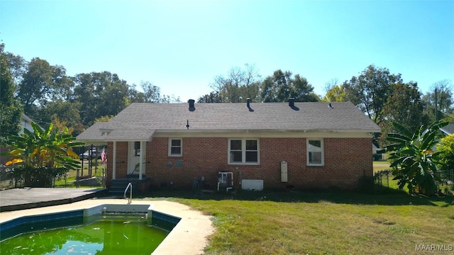 back of house with a pool side deck and a yard