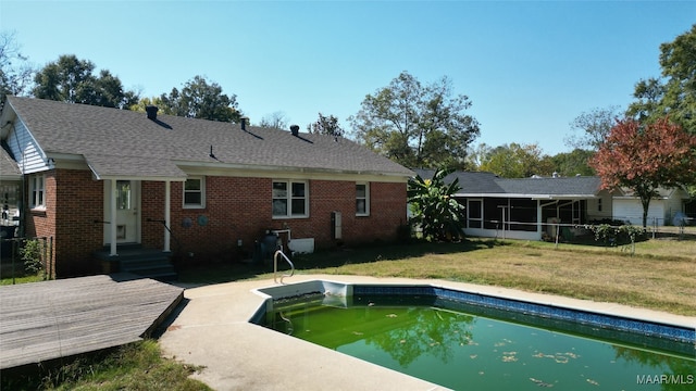 back of house featuring a sunroom and a lawn