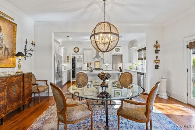 dining area with a notable chandelier, crown molding, and hardwood / wood-style flooring