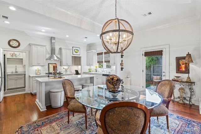 dining space with beam ceiling, ornamental molding, dark wood-type flooring, and a chandelier