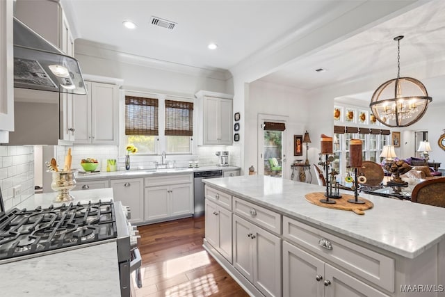 kitchen with decorative backsplash, stainless steel appliances, sink, and a kitchen island