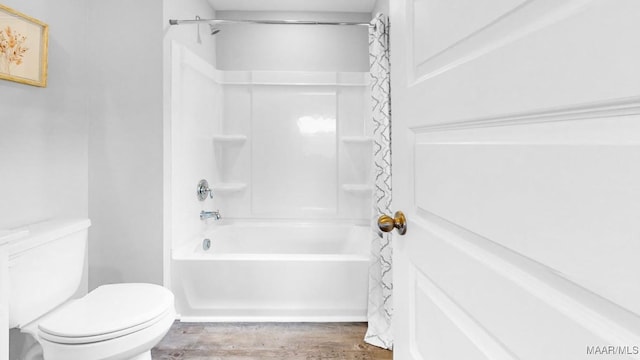 bathroom featuring hardwood / wood-style flooring, toilet, and shower / tub combo with curtain