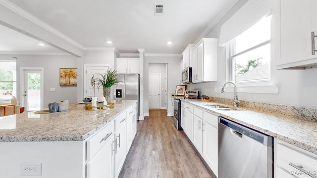 kitchen featuring white cabinetry, sink, stainless steel appliances, light hardwood / wood-style floors, and a kitchen island