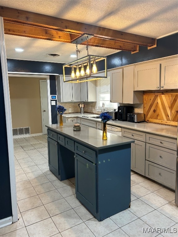 kitchen featuring light tile patterned floors, a kitchen island, a textured ceiling, beamed ceiling, and decorative light fixtures