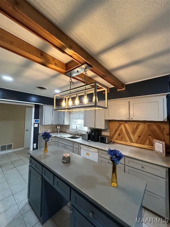 kitchen featuring dishwasher, beamed ceiling, sink, decorative light fixtures, and light tile patterned floors