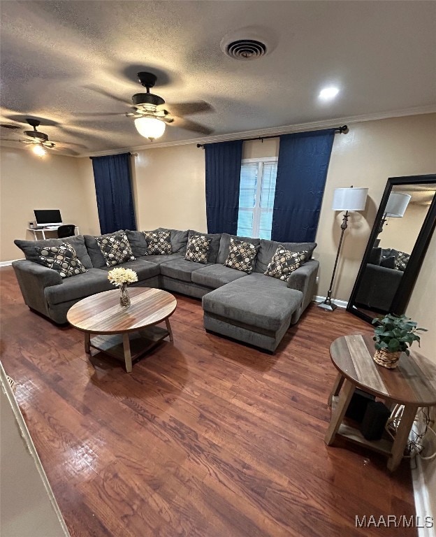 living room with ceiling fan, crown molding, a textured ceiling, and dark hardwood / wood-style flooring