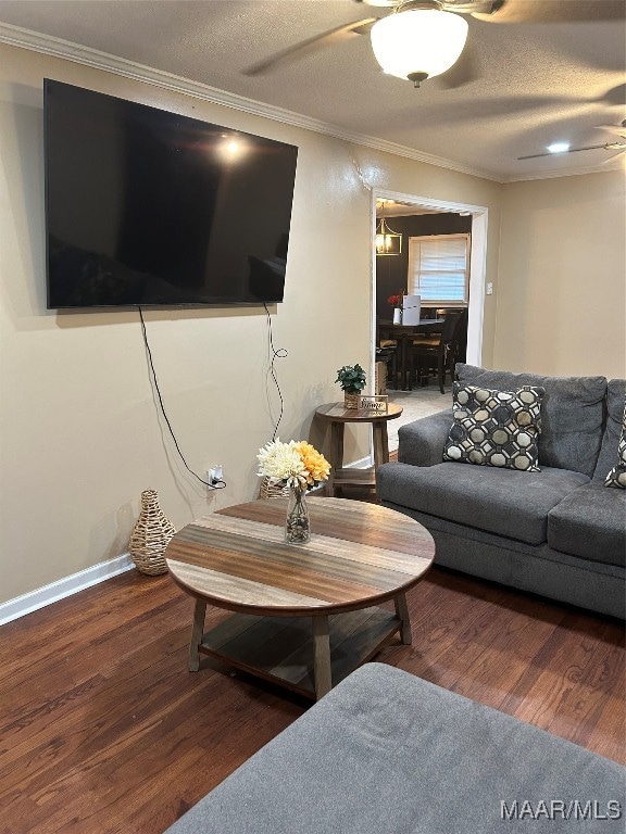 living room with ornamental molding, dark hardwood / wood-style floors, a textured ceiling, and ceiling fan