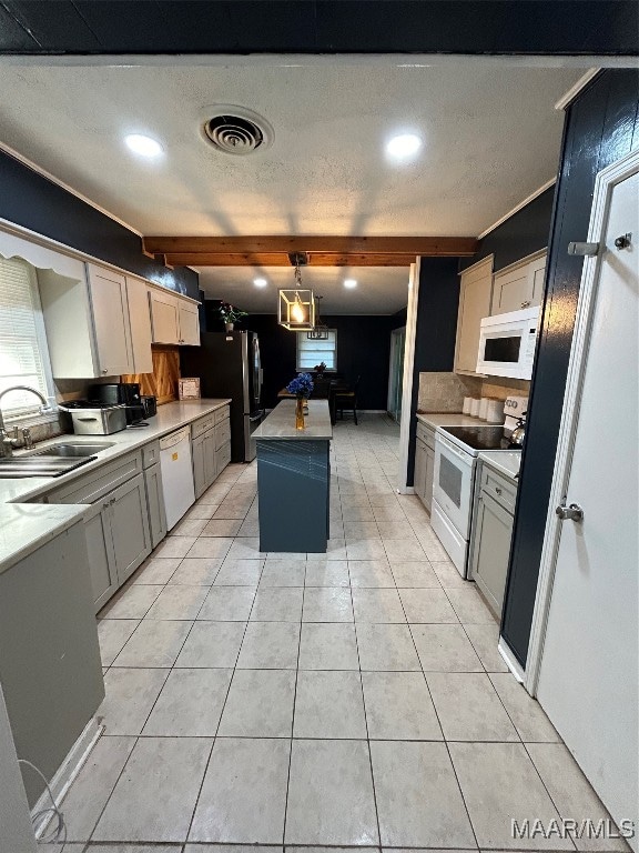 kitchen featuring light tile patterned floors, sink, a kitchen island, and white appliances