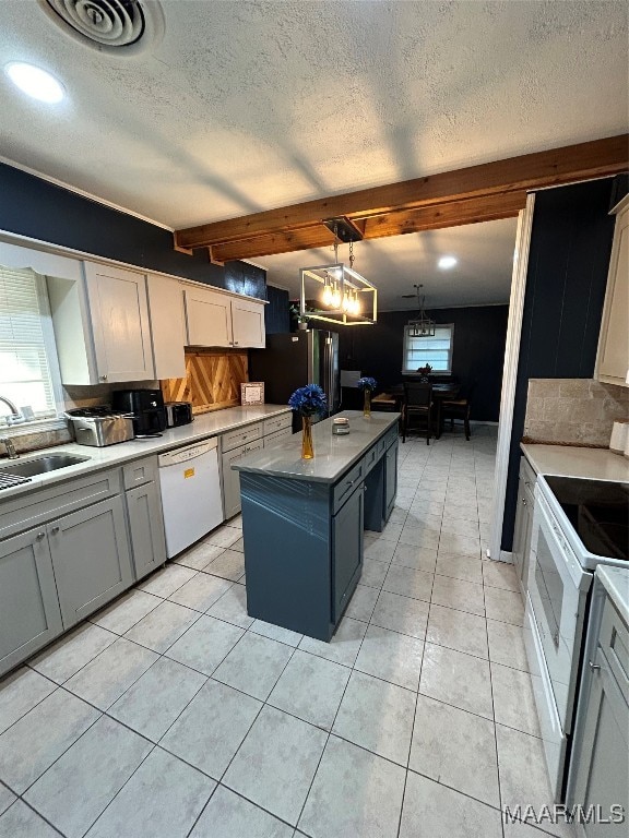 kitchen featuring beamed ceiling, a kitchen island, a textured ceiling, and white appliances