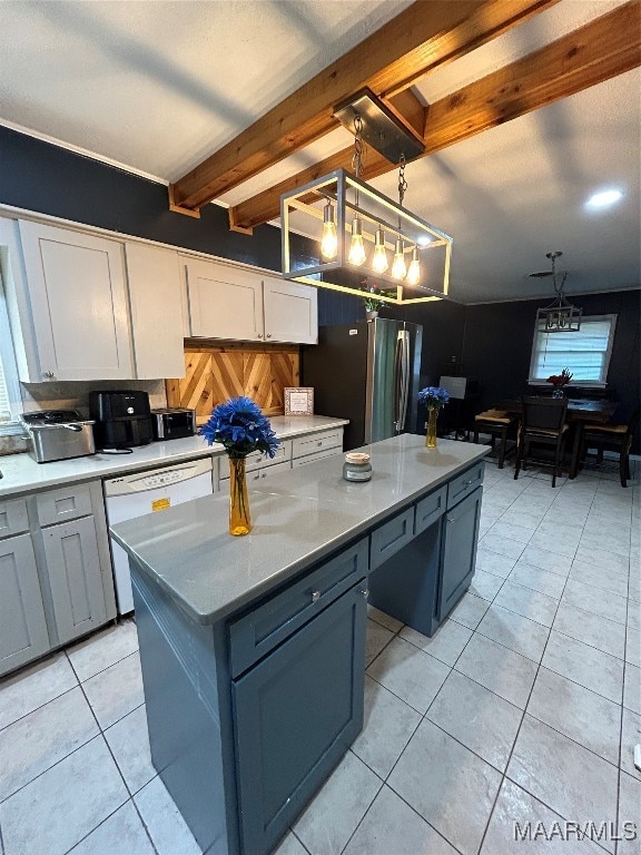 kitchen featuring white cabinets, light tile patterned floors, stainless steel refrigerator, beamed ceiling, and pendant lighting