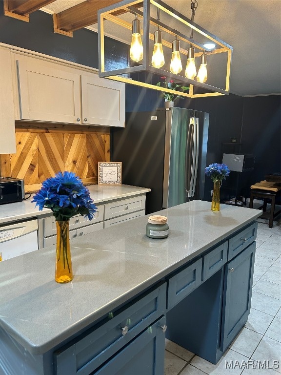 kitchen featuring light tile patterned flooring, blue cabinetry, stainless steel fridge, hanging light fixtures, and light stone counters