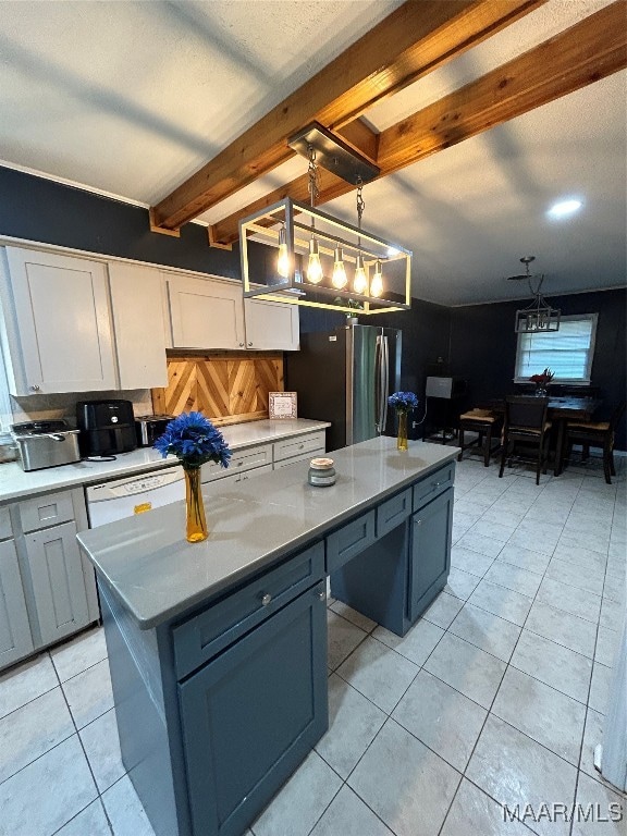 kitchen with beam ceiling, hanging light fixtures, a kitchen island, light tile patterned floors, and white cabinetry