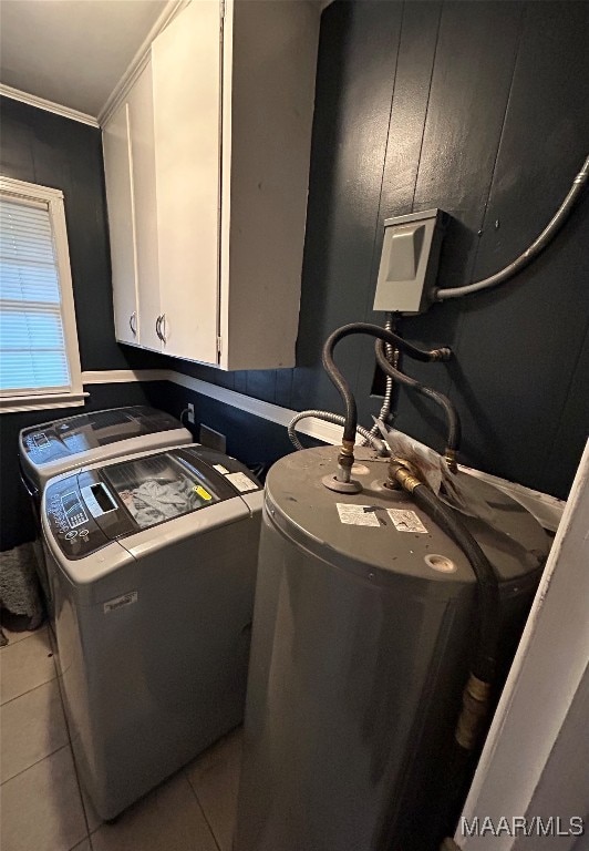 washroom featuring cabinets, crown molding, light tile patterned flooring, and washer and clothes dryer