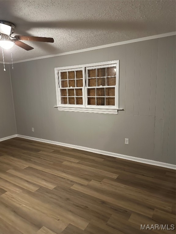 spare room with ceiling fan, crown molding, a textured ceiling, and hardwood / wood-style floors