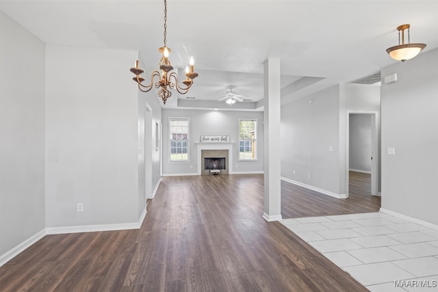 unfurnished living room featuring hardwood / wood-style flooring and ceiling fan with notable chandelier