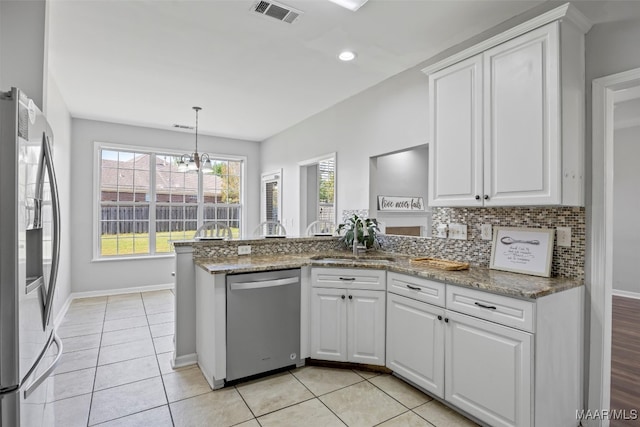 kitchen featuring appliances with stainless steel finishes, kitchen peninsula, white cabinets, and stone counters