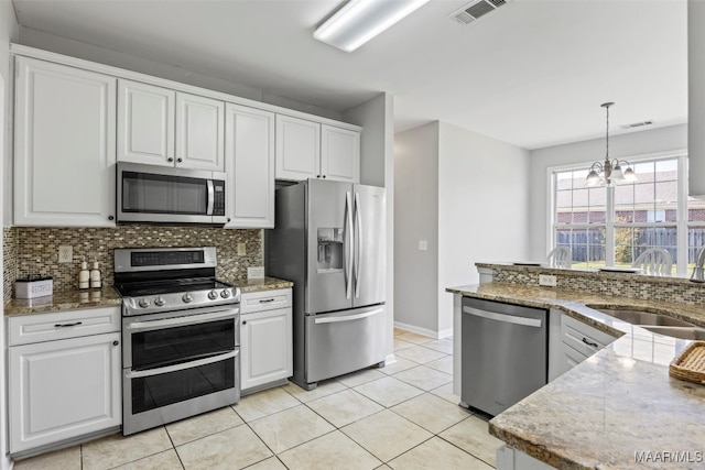 kitchen with hanging light fixtures, stainless steel appliances, sink, a chandelier, and white cabinetry