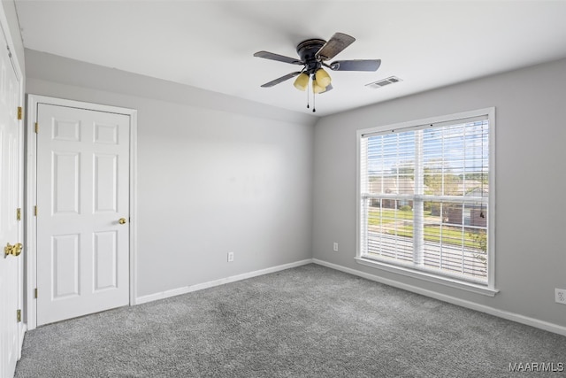 unfurnished room with ceiling fan and carpet